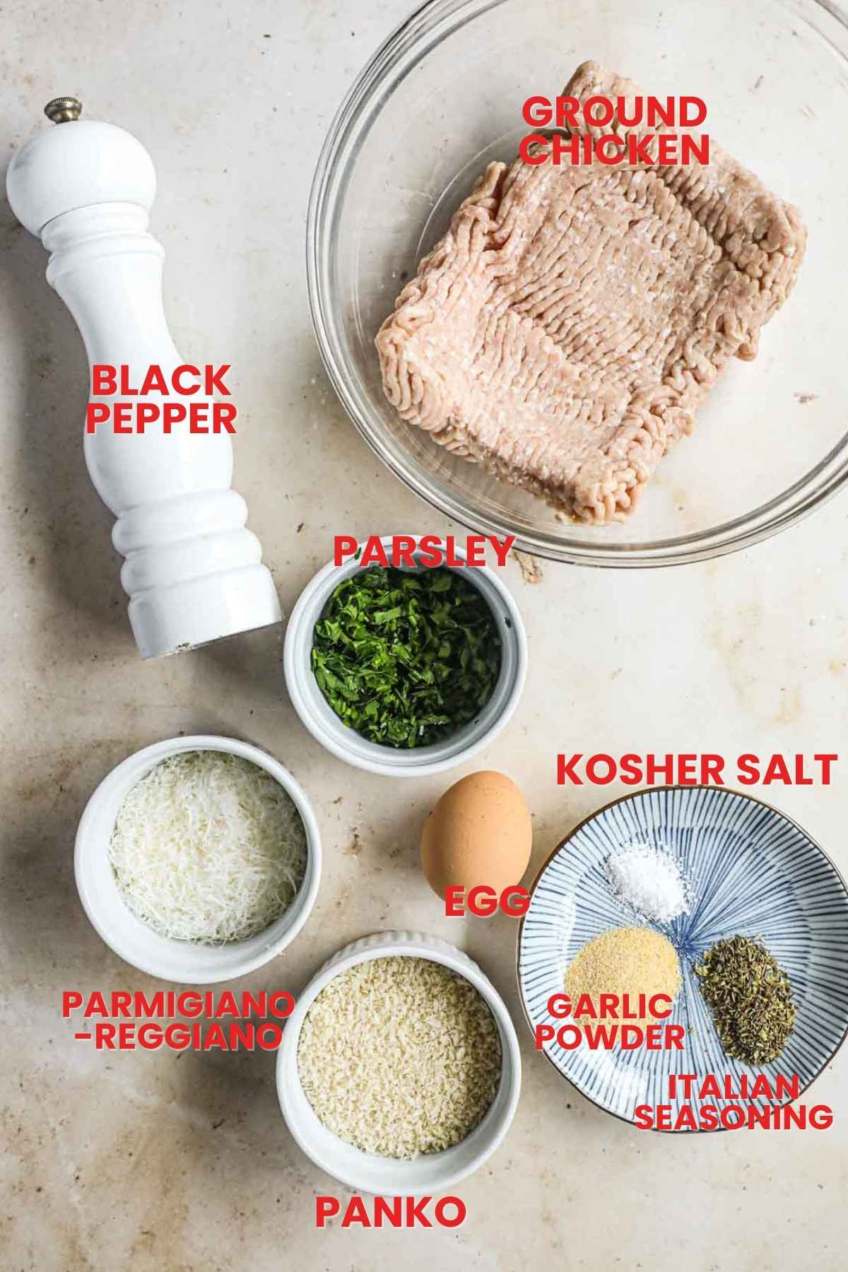 Ingredients to make chicken meatballs, including ground chicken, italian parsley, italian seasoning, garlic powder, parmigiano-reggiano, panko, black pepper.