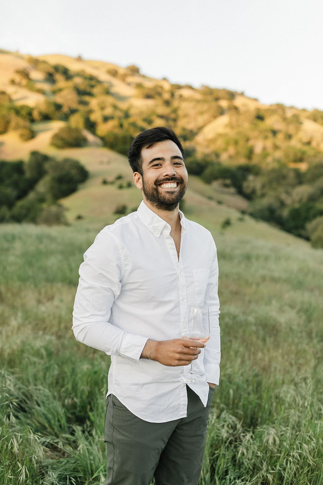 Alec, founder of Happy Gut Lucky, smiling with a glass of wine in Marin County.